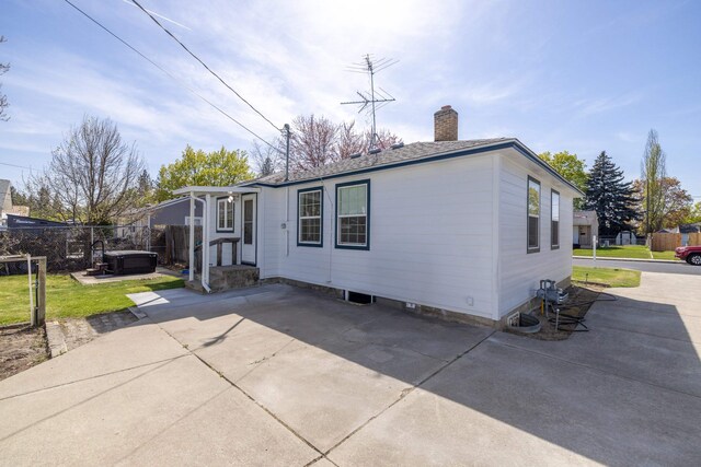 manufactured / mobile home featuring a jacuzzi, a patio area, a chimney, and fence