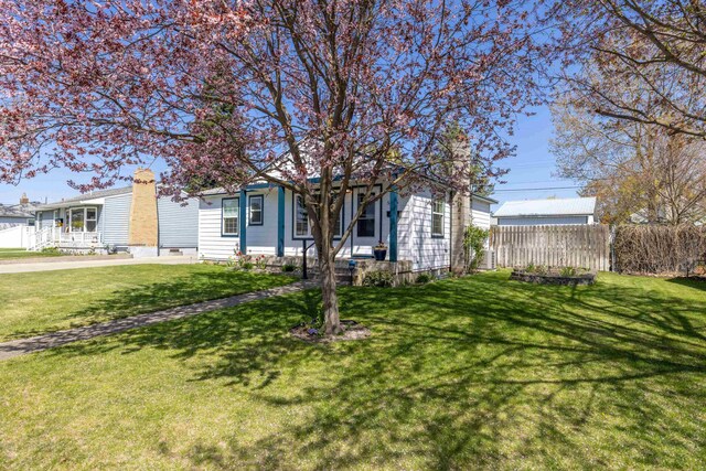 view of front of home with a front lawn, fence, and a chimney