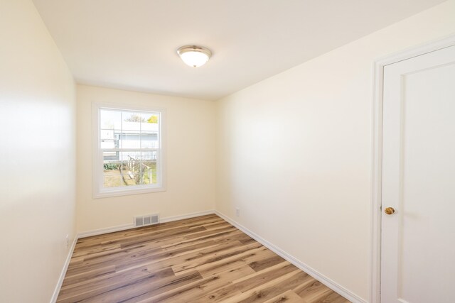 unfurnished room featuring light wood-style floors, baseboards, and visible vents