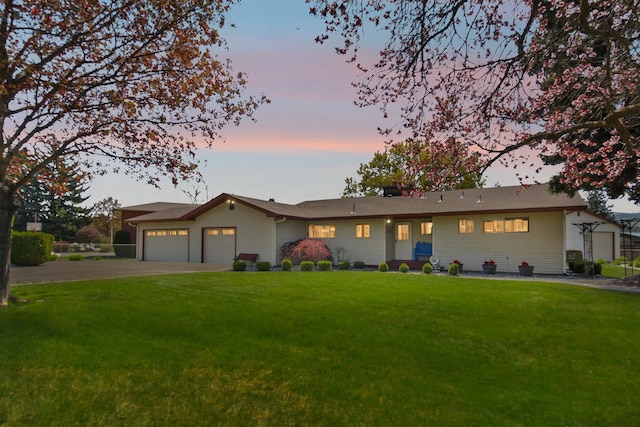 ranch-style home with a garage, driveway, and a front yard
