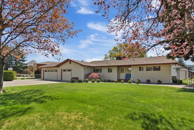 ranch-style house featuring a garage, a front lawn, and concrete driveway