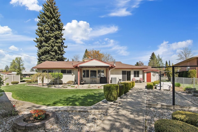 back of property with fence, a storage shed, an outbuilding, a patio area, and a yard