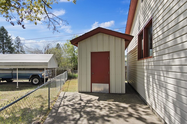 view of shed with fence and a carport