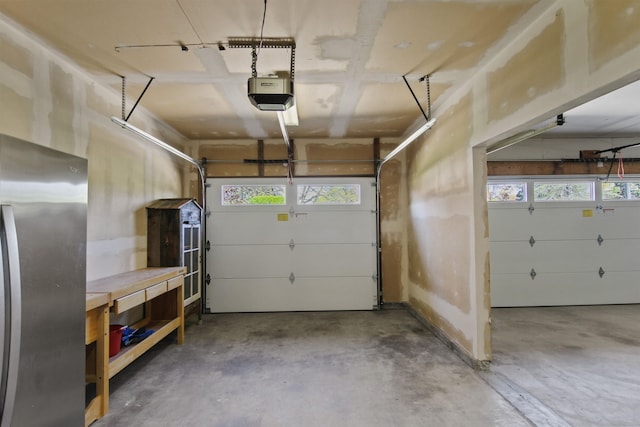 garage with freestanding refrigerator and a garage door opener