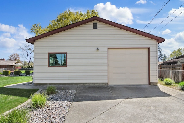 detached garage with fence and concrete driveway