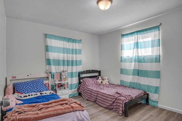 bedroom featuring baseboards and wood finished floors