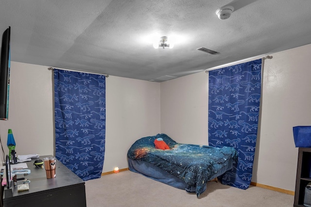 bedroom with a textured ceiling, visible vents, baseboards, and carpet