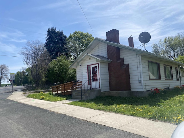 view of home's exterior with a lawn and a chimney