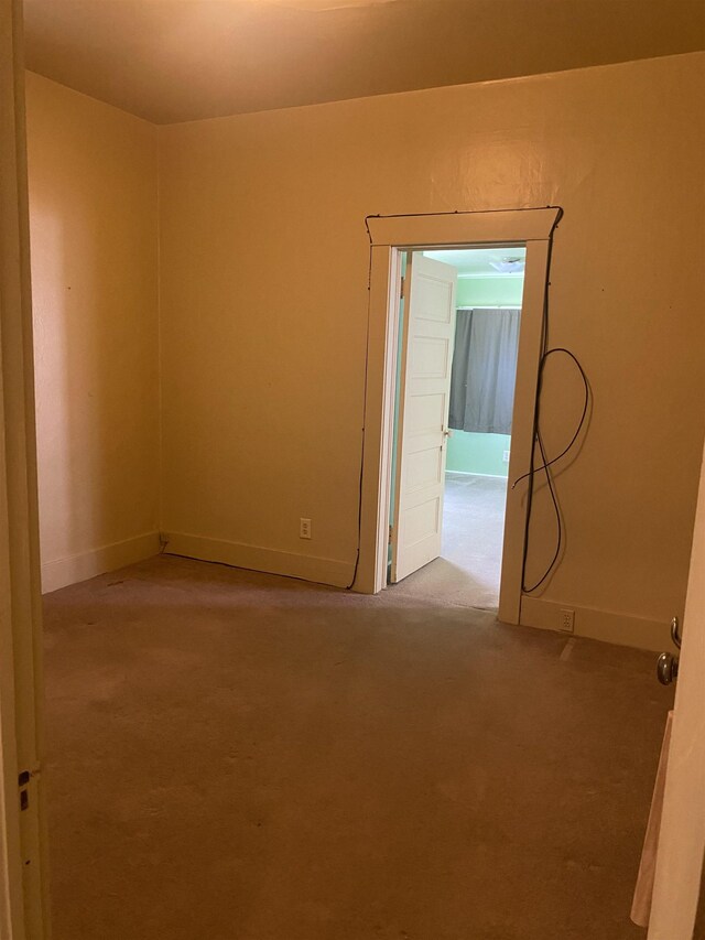 spare room with baseboards and carpet flooring