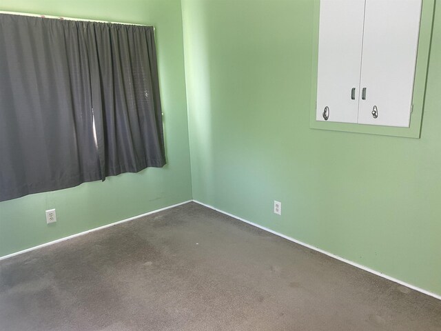 empty room featuring baseboards and carpet