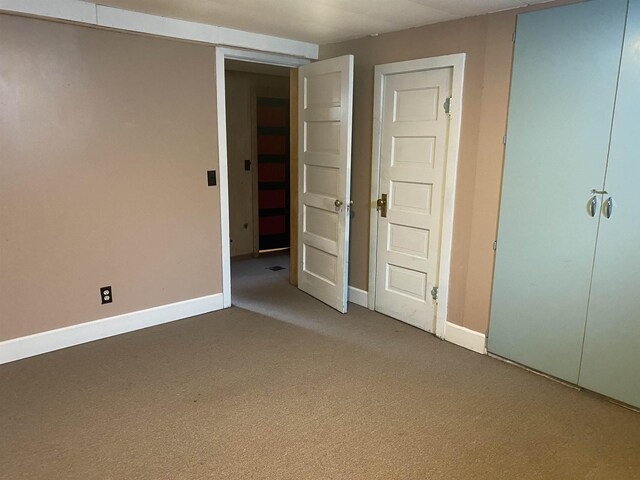 unfurnished bedroom with baseboards and carpet