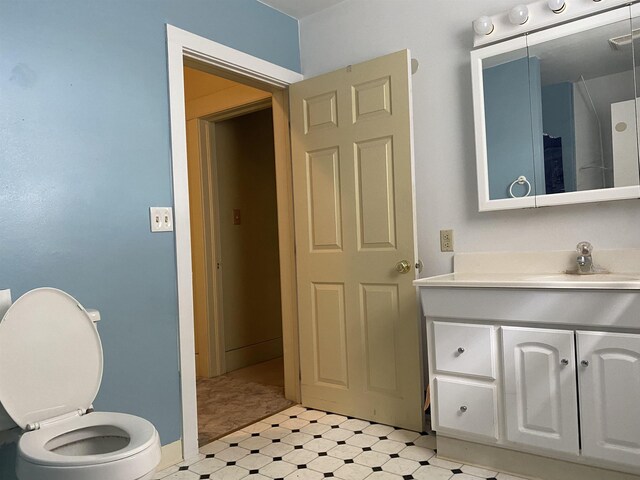 bathroom featuring vanity, baseboards, visible vents, and toilet