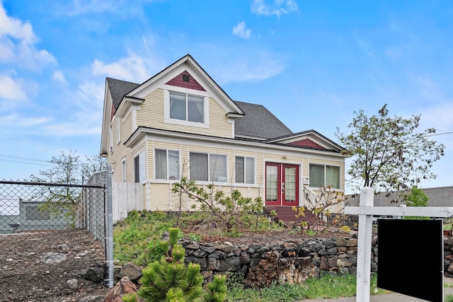 view of front of property with a shingled roof, fence, french doors, and a gate