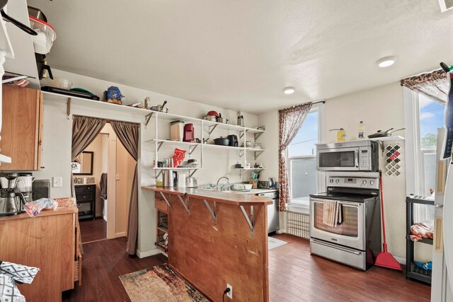 kitchen with appliances with stainless steel finishes, open shelves, and dark wood-type flooring