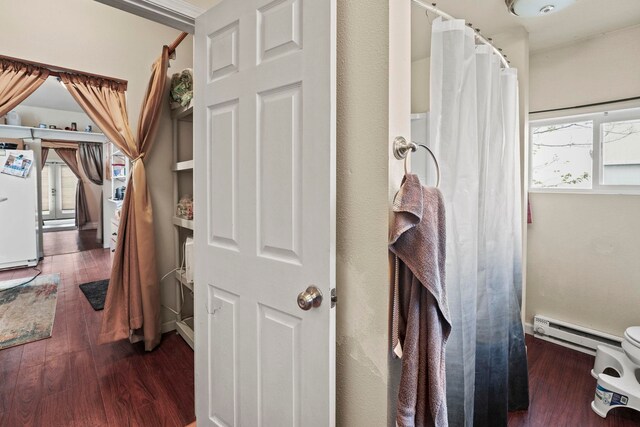 hallway with a baseboard radiator and wood finished floors