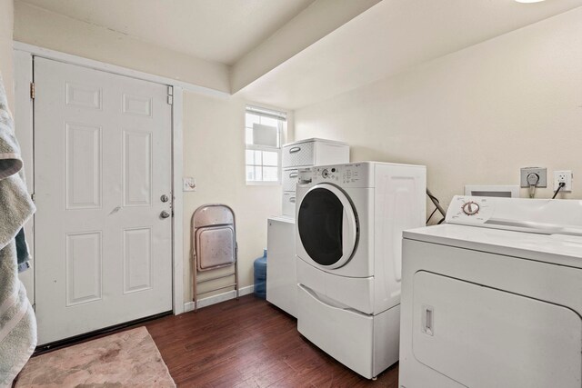 laundry area with laundry area, washer and clothes dryer, baseboards, and dark wood-style floors