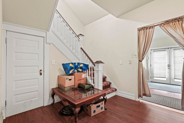 foyer with baseboards, stairs, and wood finished floors