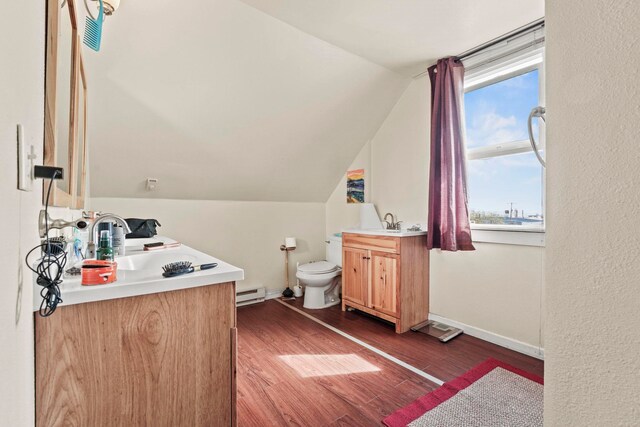 bathroom featuring toilet, a baseboard radiator, a healthy amount of sunlight, and vanity