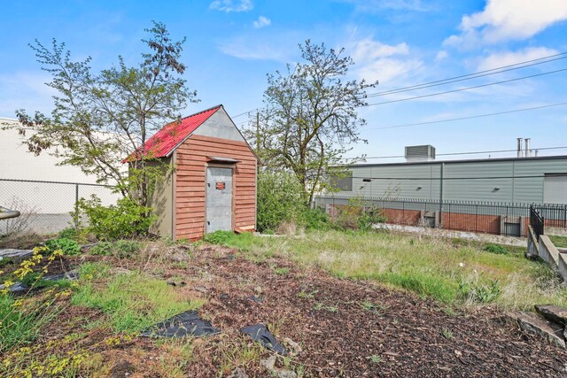 view of yard with a storage shed, fence, and an outdoor structure