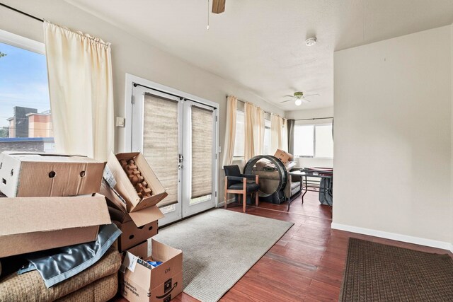 living room with baseboards, a ceiling fan, and wood finished floors