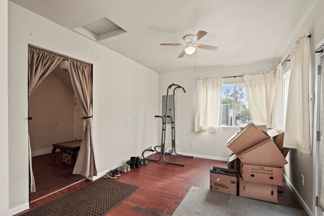 exercise area featuring baseboards, ceiling fan, and wood finished floors