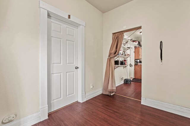 interior space featuring baseboards, wood finished floors, and visible vents