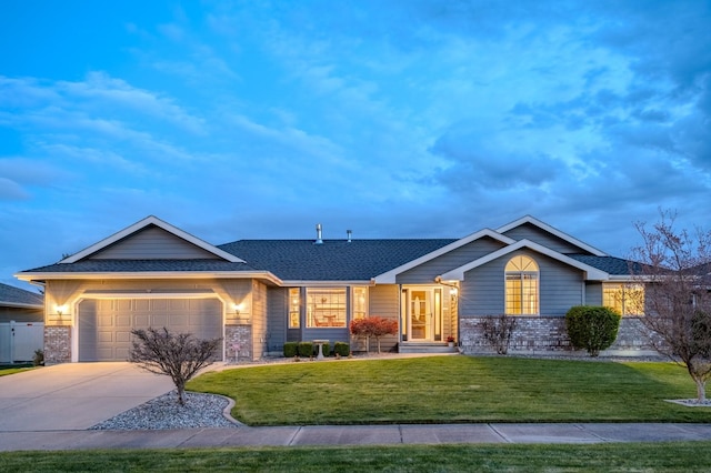 view of front of property featuring an attached garage, a shingled roof, brick siding, concrete driveway, and a lawn