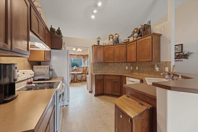 14316 E 31st Ln, Veradale, WA 99037 - kitchen with decorative backsplash, a sink, light floors, under cabinet range hood, and white appliances