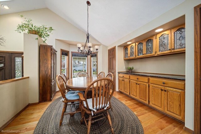 dining area featuring recessed lighting, high vaulted ceiling, an inviting chandelier, and light wood finished floors