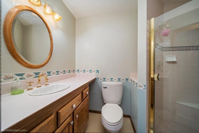 bathroom with vanity, toilet, and a shower stall
