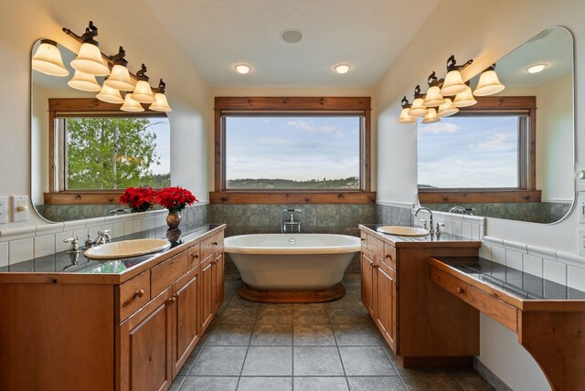 full bathroom with a freestanding bath, a wainscoted wall, and vanity