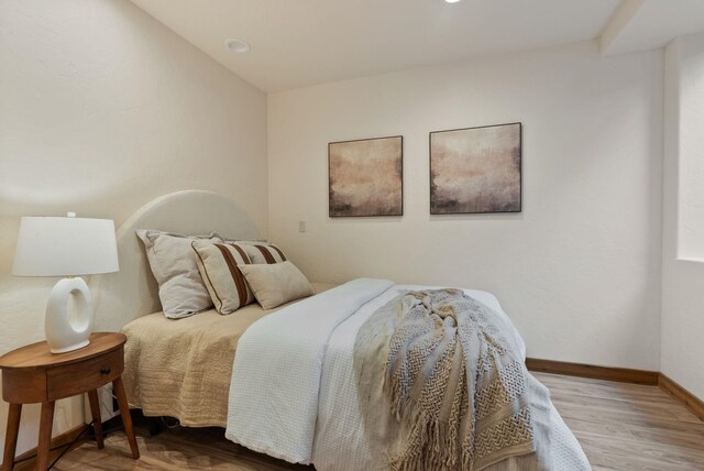 bedroom featuring baseboards and wood finished floors