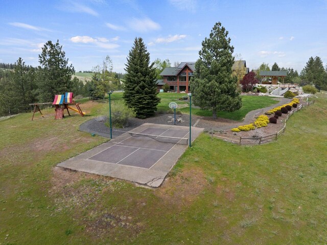 view of property's community featuring a lawn, uncovered parking, and playground community