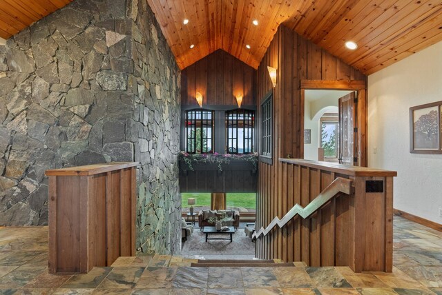 bar featuring stone finish floor, plenty of natural light, and wood ceiling