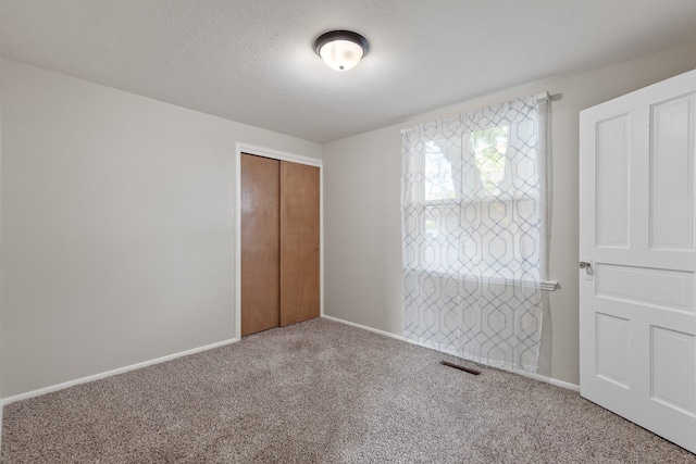 unfurnished bedroom with carpet flooring, baseboards, and a closet