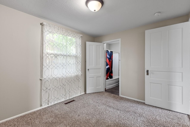 unfurnished bedroom with carpet flooring, baseboards, and visible vents