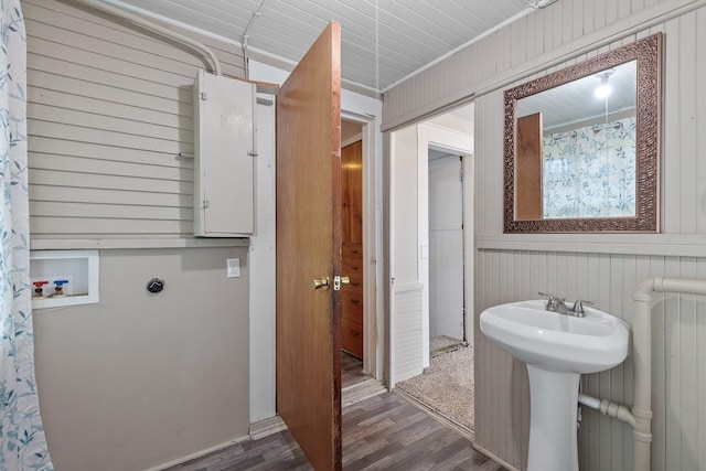 bathroom featuring wooden walls, radiator, and wood finished floors