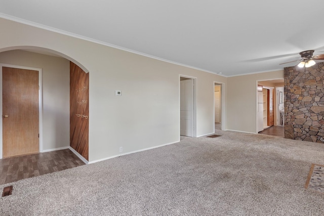 unfurnished living room featuring crown molding, baseboards, ceiling fan, and carpet flooring