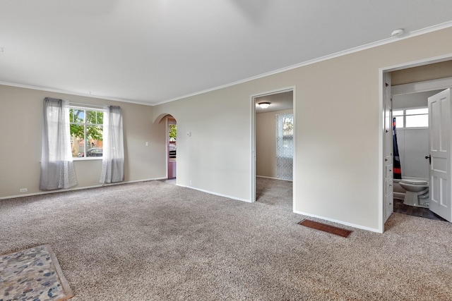 interior space with baseboards, arched walkways, carpet, and ornamental molding