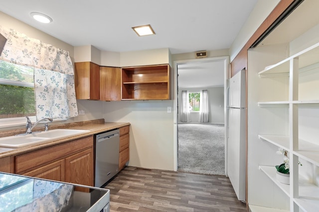kitchen featuring stainless steel dishwasher, open shelves, wood finished floors, a sink, and freestanding refrigerator