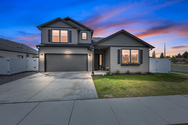 view of front of home featuring a gate, an attached garage, concrete driveway, and a front yard