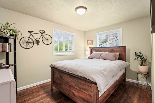 bedroom with a textured ceiling, baseboards, and dark wood-style floors