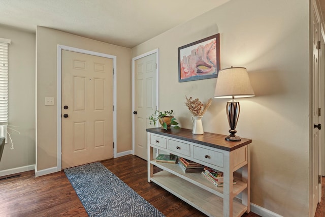 entryway featuring baseboards and dark wood-style flooring
