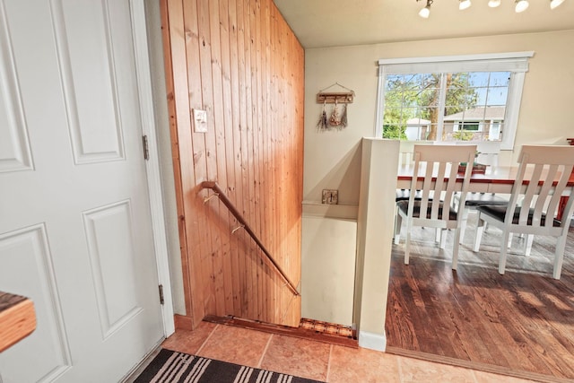 stairway featuring wood walls