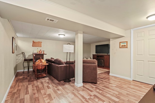 living area with baseboards, visible vents, light wood-style flooring, and a fireplace
