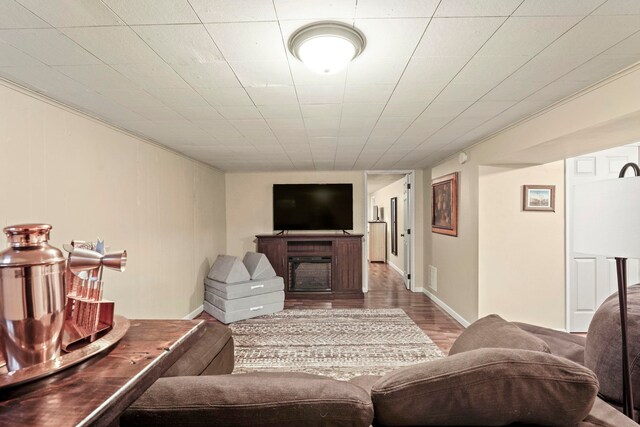 living area with baseboards, a fireplace, wood finished floors, and visible vents