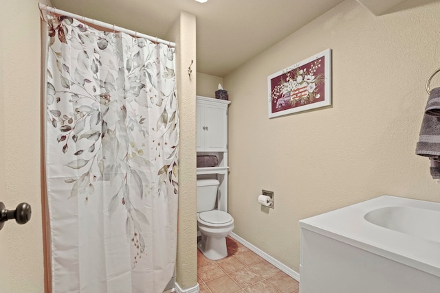 bathroom featuring a shower with curtain, tile patterned flooring, a sink, baseboards, and toilet