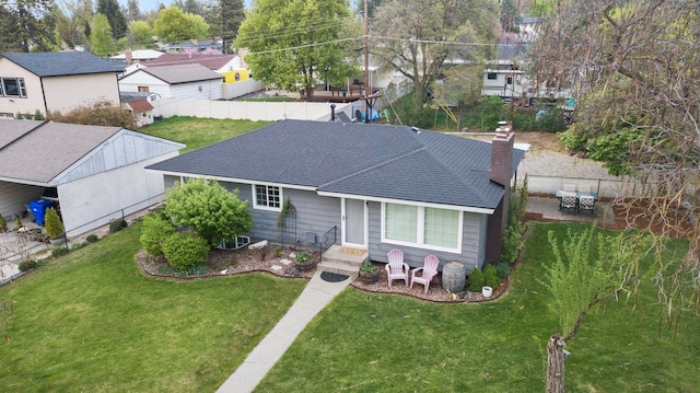 single story home with roof with shingles, fence, and a front yard