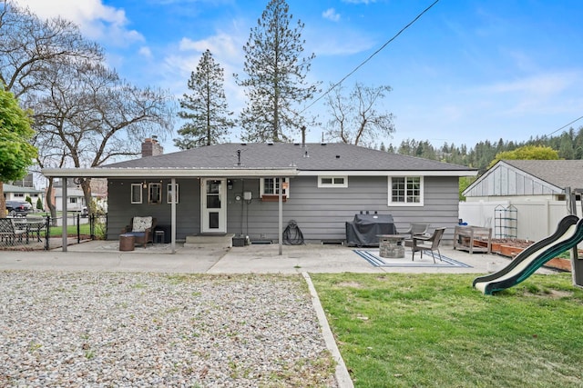 rear view of house featuring entry steps, fence, a patio, and a chimney