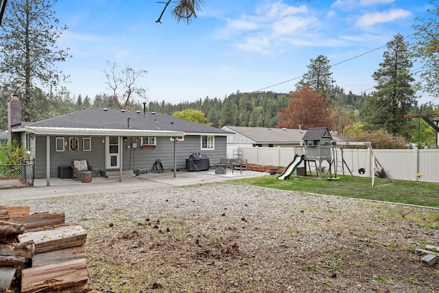 rear view of house with a yard, entry steps, a fenced backyard, and a patio area